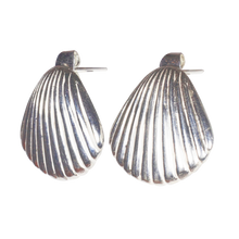 A pair of silver-colored earrings with a shell design.
