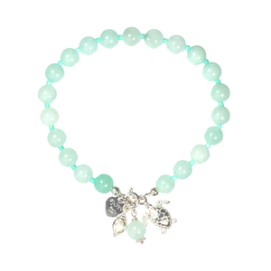 Turquoise beaded bracelet with silver charms on a white background