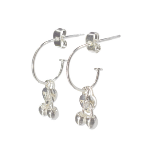 Silver hoop earrings with dangling cherry charms on a white background