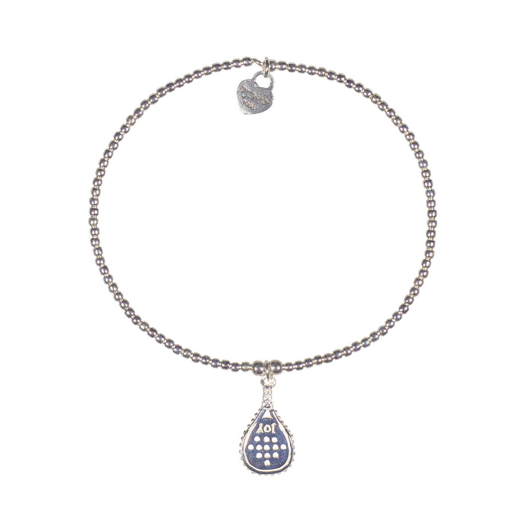 A sterling silver bracelet featuring a small padel racket charm and 2mm beads strung on elastic, with a signature logo at the clasp.