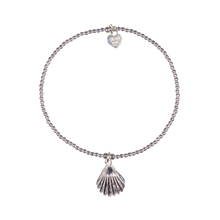 Silver bracelet with shell charm on white background