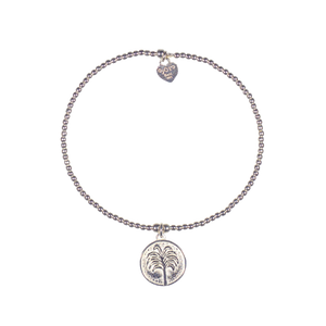 A 925 sterling silver bracelet featuring a small coin featuring a tropical tree and a signature logo.